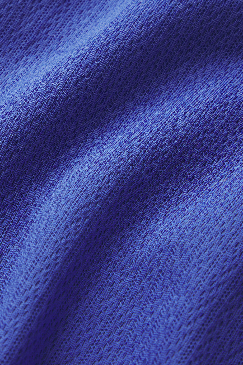 Close-up of the Pointelle Pajama Shorts Set in Cobalt, showing the detailed weave and soft folds of the blue Pima cotton fabric, with gentle shadows and highlights across the material.