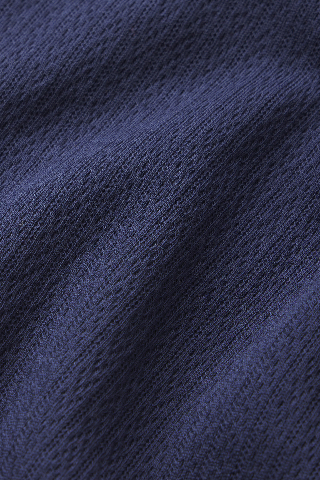 Close-up of the Pointelle Pants Bundle in English Navy, featuring fine Pima cotton fabric with textured diagonal lines and gentle folds that create soft shadows and highlights.