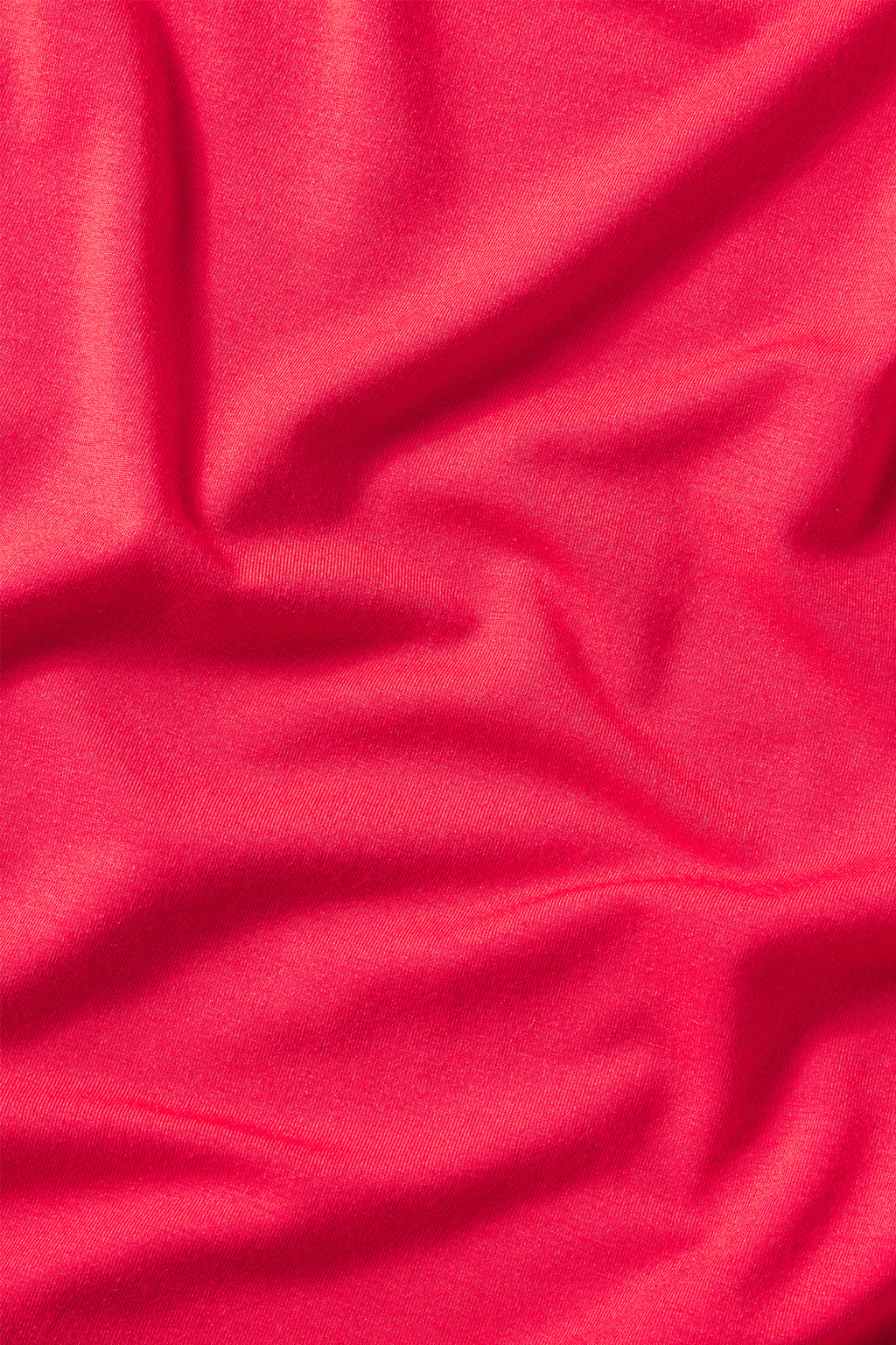 Smooth, bright pink DreamModal Ribbon Long-Long Set in Ski Patrol fabric with visible folds that create areas of light and shadow across its surface.