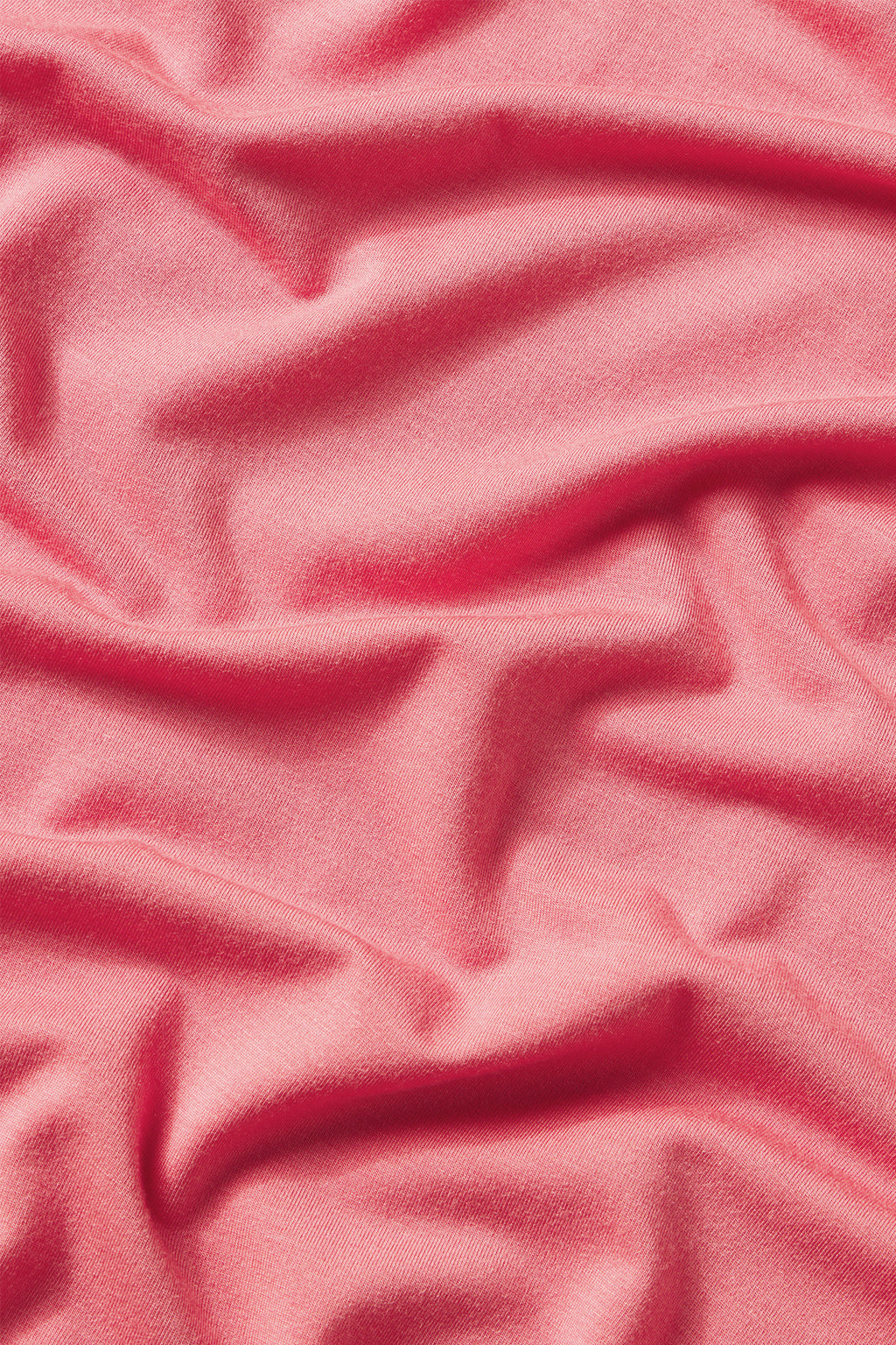 A close-up of soft, pink modal fabric from the DreamModal Ribbon Long-Short Set in Winterberry, showing textured folds and a subtle sheen—perfect for cozy pajama shorts.