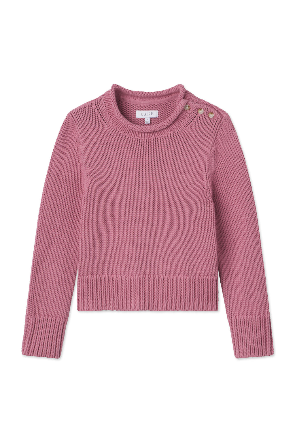 The Jane Cotton Sweater in Light Camellia is a chunky cotton knit with long sleeves, a round neckline, and two decorative buttons on one shoulder, shown against a white background.