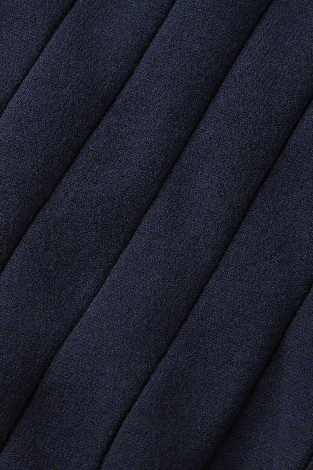 Close-up of deep navy, quilted fabric with parallel raised seams creates a textured, padded look—perfect for cozy days at home in the Vesper Jogger Set in Deep Navy.