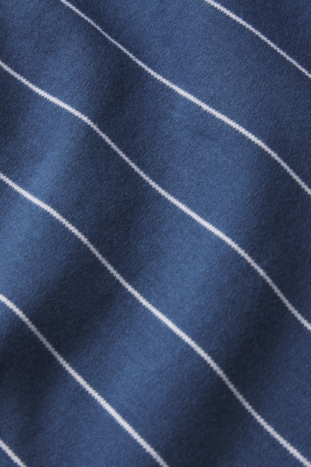 Close-up of the Pima Long-Long Set in Navy Boating Stripe, featuring blue fabric with thin white stripes. The soft 100% Pima cotton material shows visible texture and gentle folds.