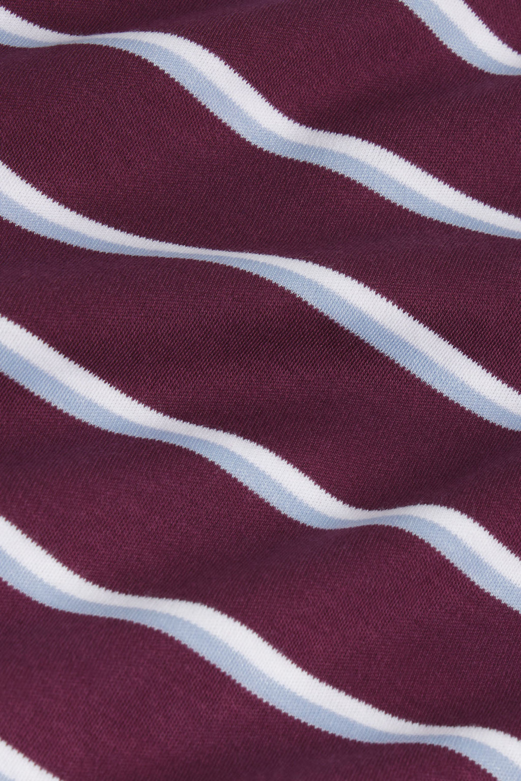 Burgundy fabric with diagonal wavy stripes in light blue and white.