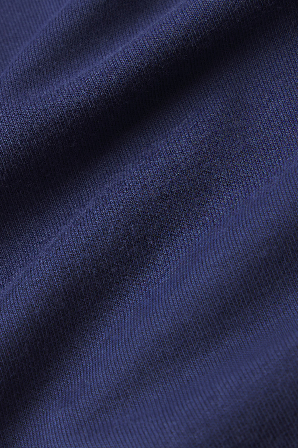 Close-up of the English Navy Wide Leg Lounge Pant’s dark blue Pima blend fabric, featuring a ribbed texture with visible folds that create subtle shadows and highlights.