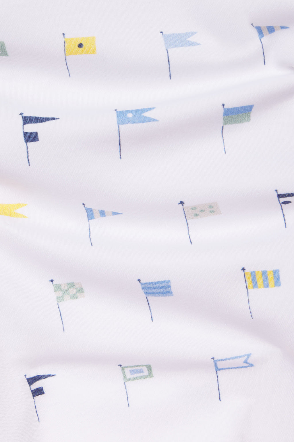 The Kids Long-Long Set in Baltic Blue Nautical Flags features soft white Pima cotton adorned with small nautical flags in blue, yellow, and green, arranged neatly across the fabric.