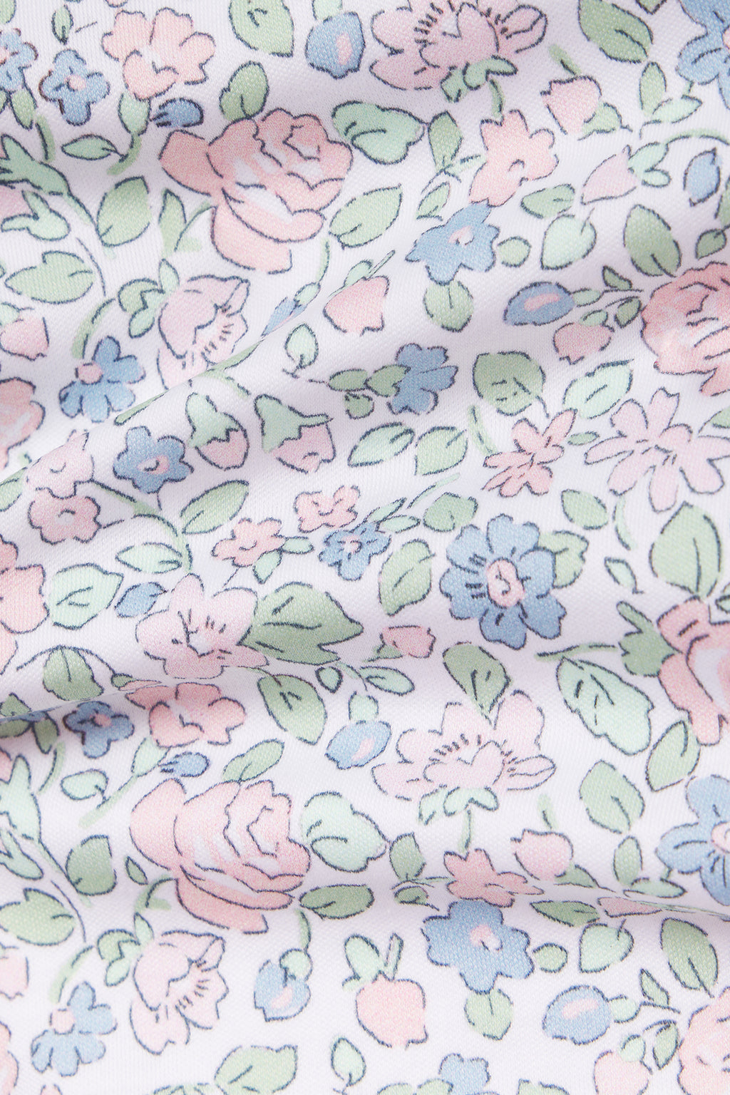 A close-up of the Kids Long-Long Set in English Rose Elizabeth Floral shows white 100% Pima cotton fabric with a pastel pink, blue, and green floral pattern. The soft folds lend a delicate, vintage-inspired look to this charming kids’ sleepwear.