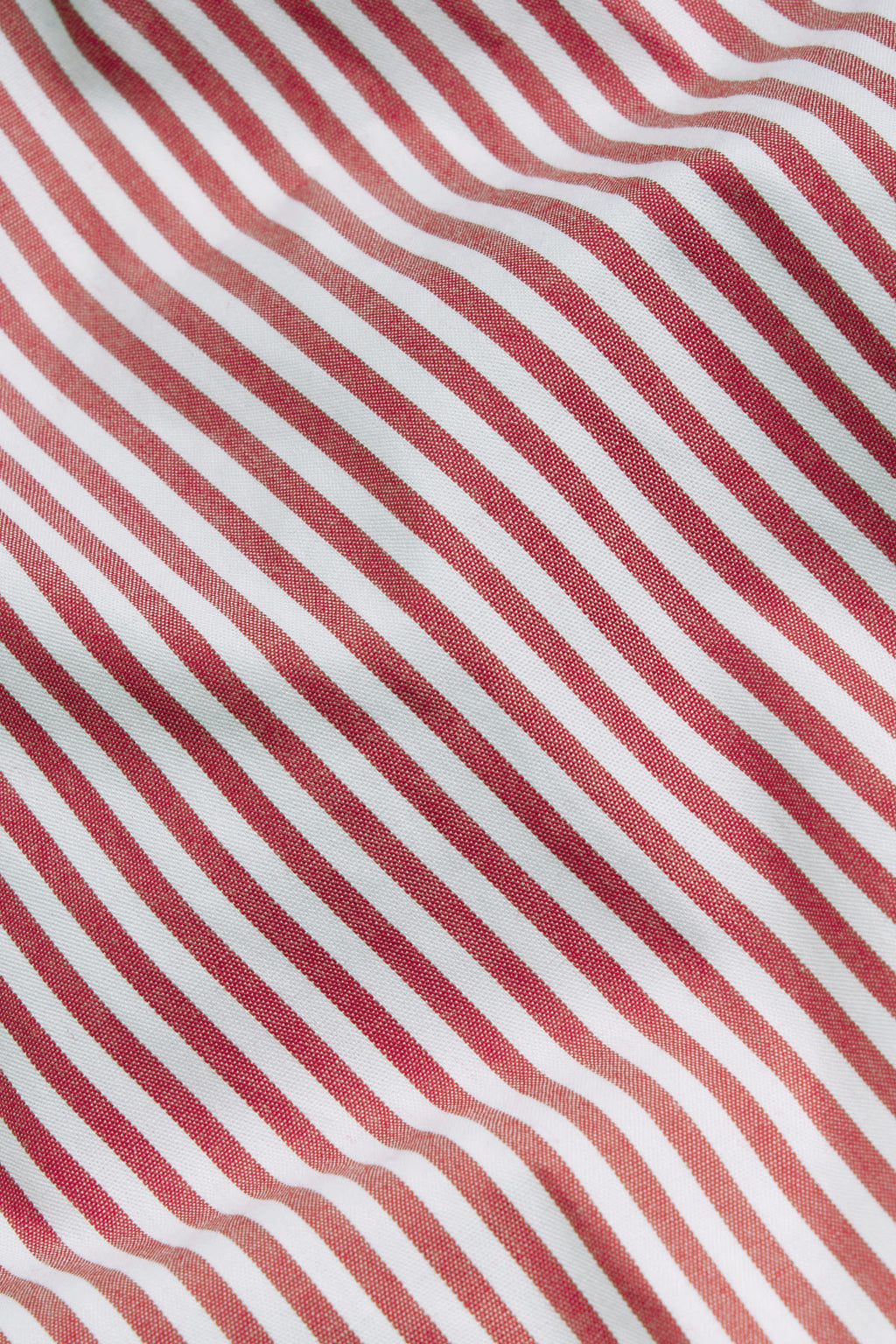Red and white diagonal striped poplin fabric with textured weave surface.