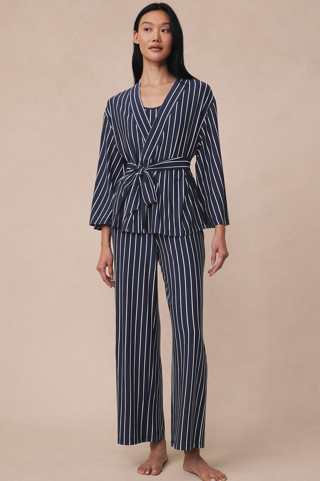 Woman wearing navy vertical striped kimono top and matching pants with tie waist.