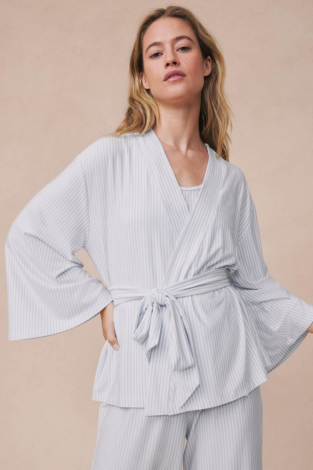 Light gray ribbed kimono jacket with tie waist worn over matching ribbed pants.