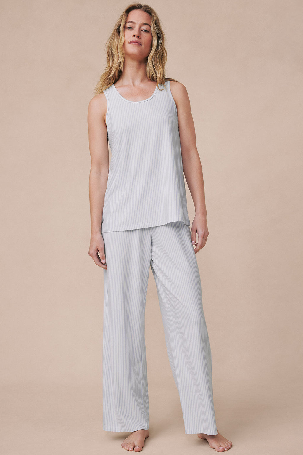 Woman wearing light gray ribbed sleeveless tank top and matching wide-leg pants in fog color.