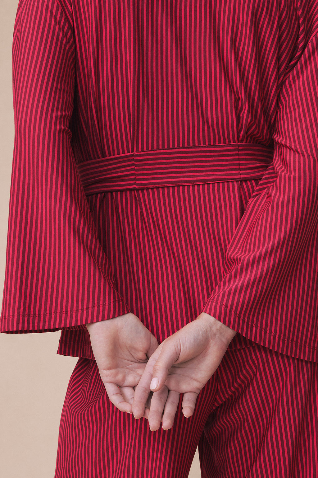 Burgundy and navy vertical striped kimono-style top with matching belt and pants on model.
