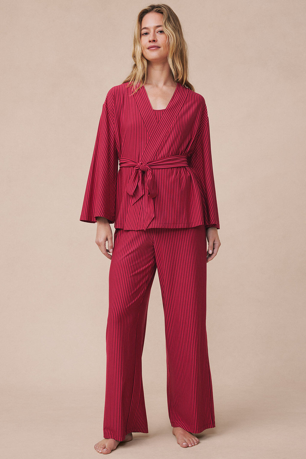 Woman wearing burgundy pencil-striped kimono with matching wide-leg pants and tied waist belt.