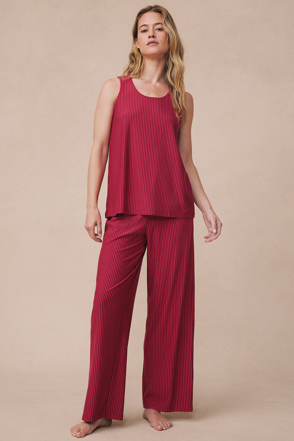 Woman wearing burgundy ribbed sleeveless tank top and matching wide-leg pants with vertical stripe pattern.