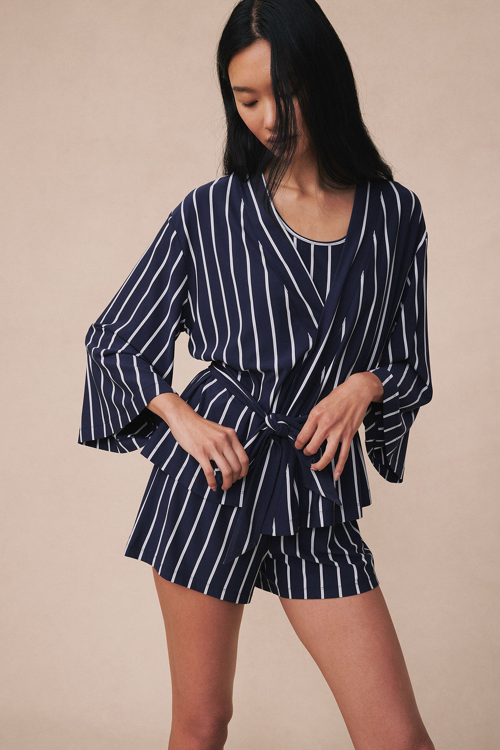 Woman wearing navy and white striped kimono robe with matching shorts, tied at waist.