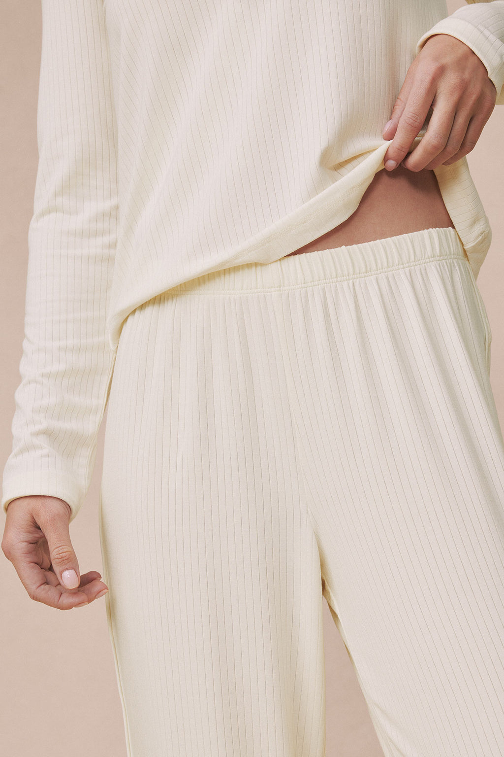 Ivory ribbed long-sleeve top and matching pants set with scoop neckline on model.