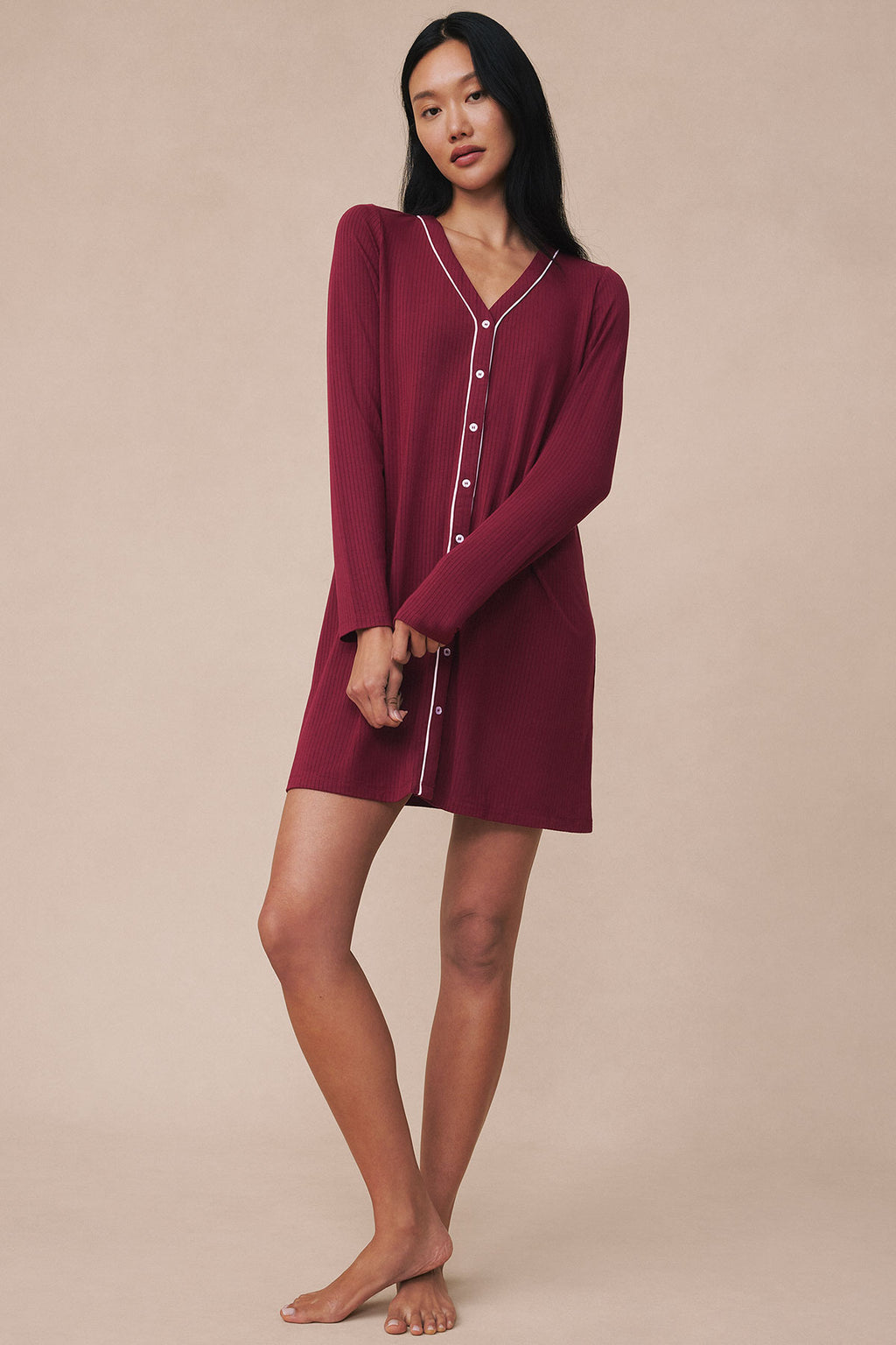 Burgundy long sleeve nightgown with white piping and button front closure on model.