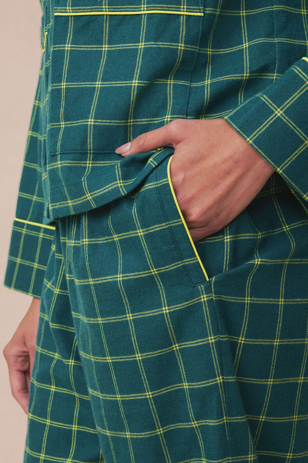 Dark teal flannel pants with yellow and cream windowpane plaid pattern, shown with hand in pocket.