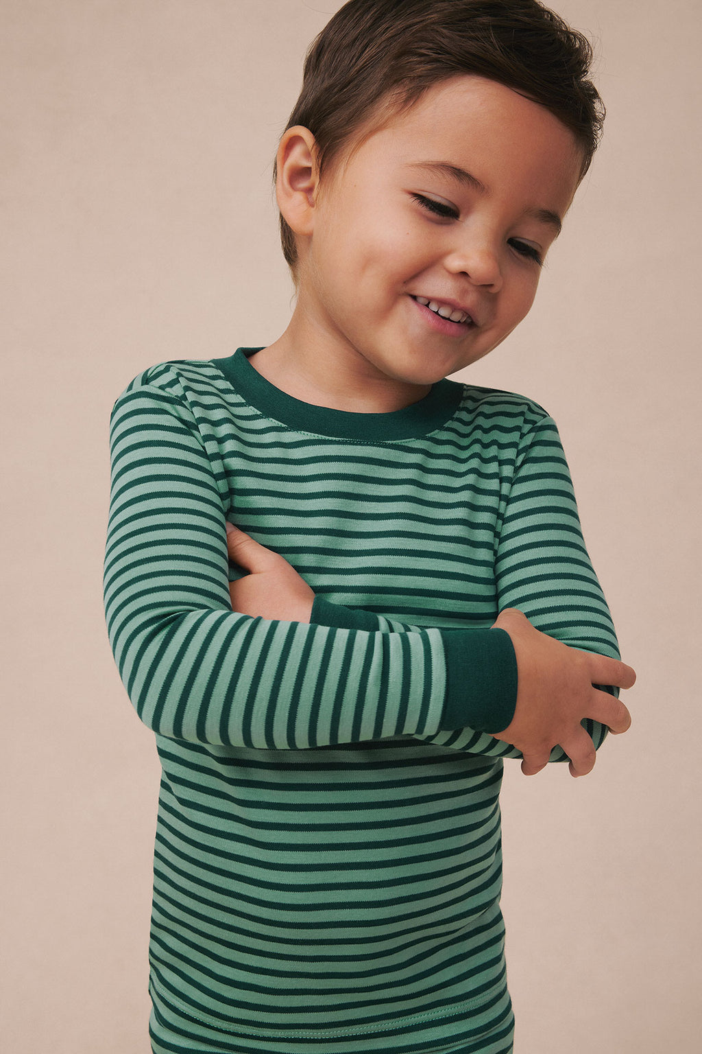 Child wearing long-sleeved shirt with dark green and light green horizontal stripes throughout.
