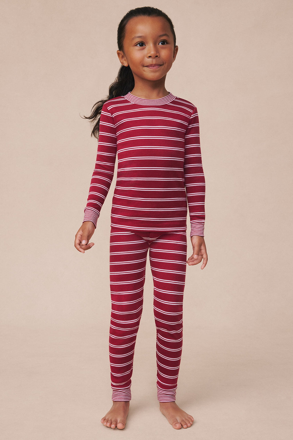Child wearing garnet and white striped long-sleeve top and matching full-length pants with ribbed cuffs.