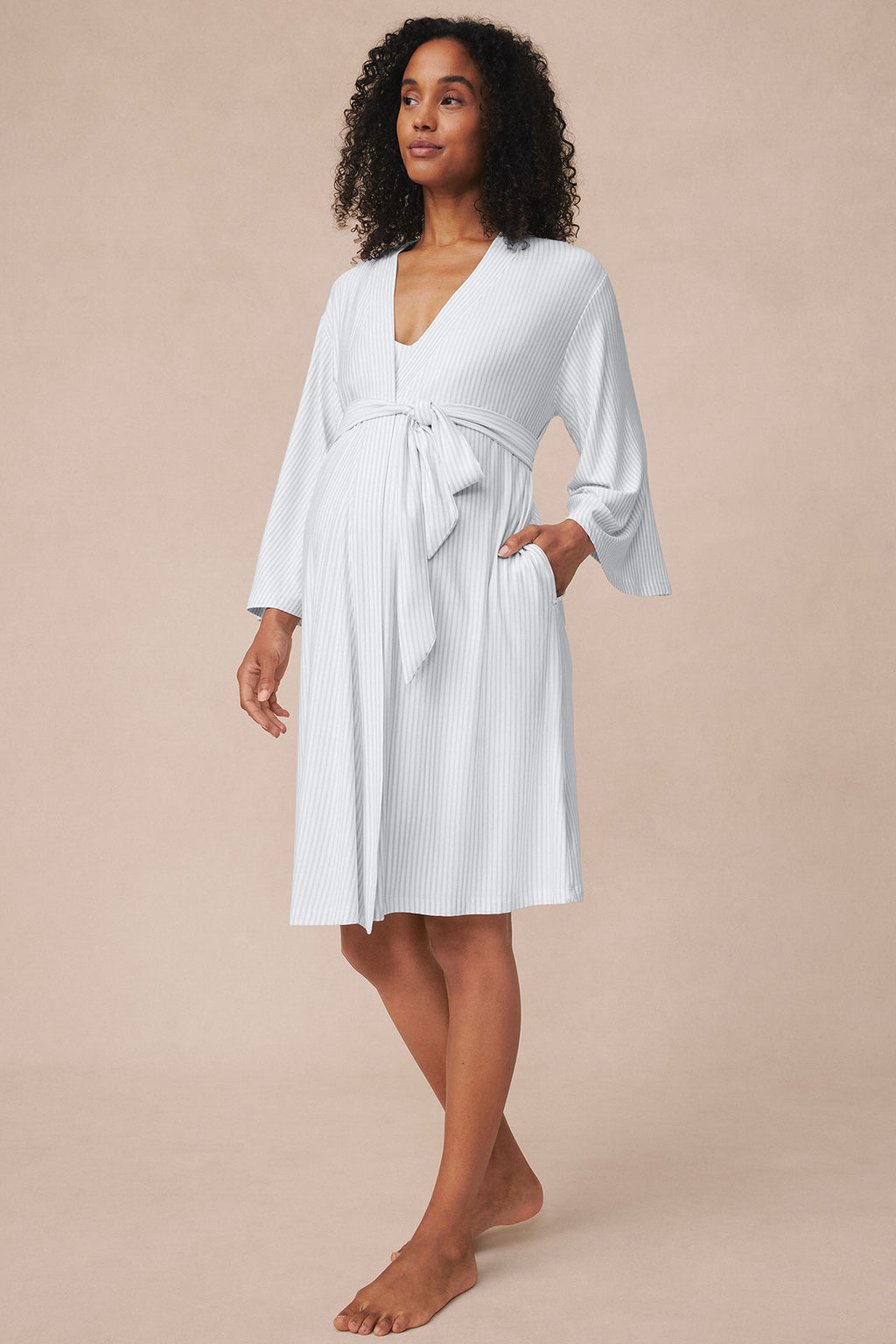 Pregnant woman wearing a light gray ribbed kimono nightgown with tie waist and three-quarter sleeves.