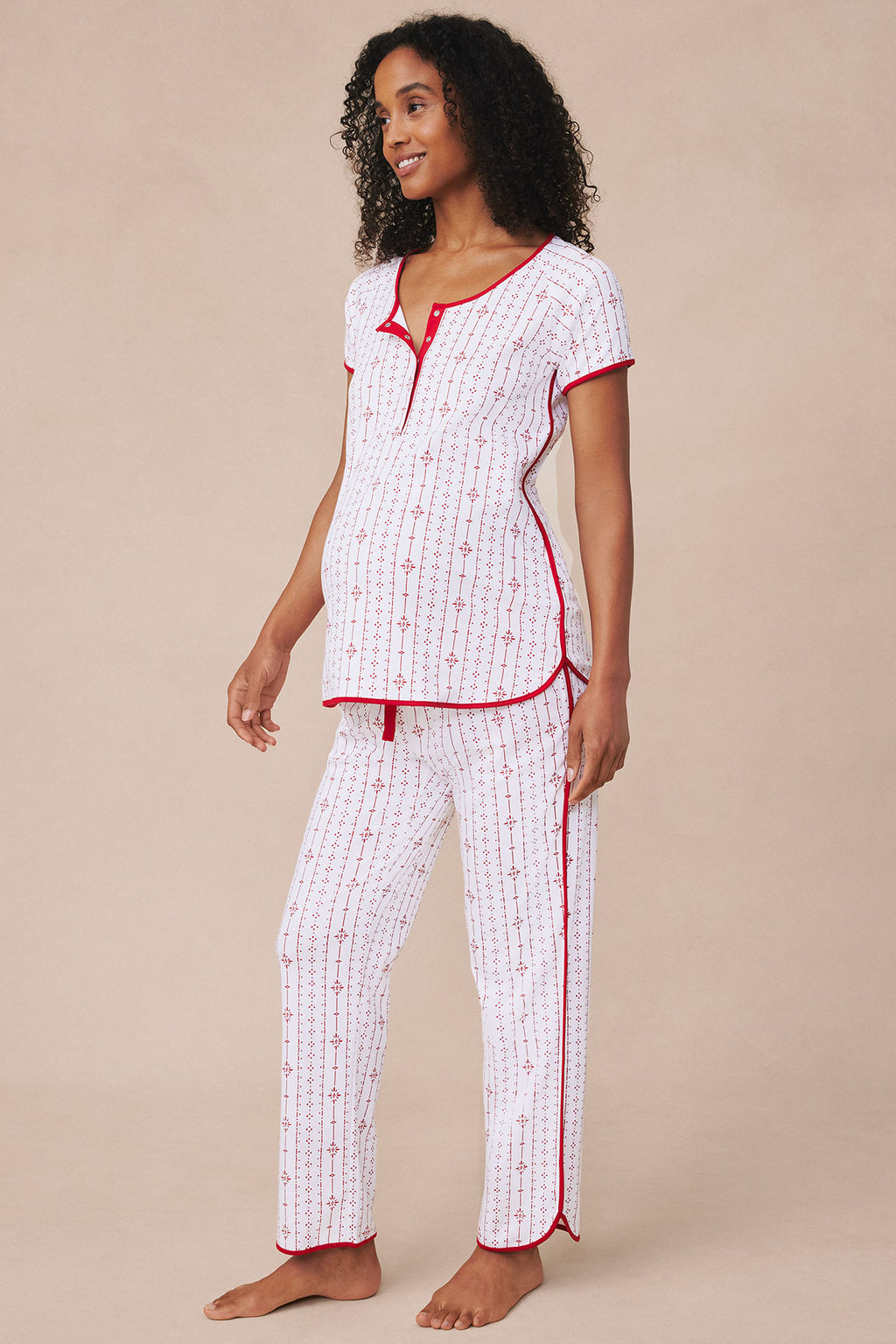 Woman wearing white and red striped short-sleeve top and matching long pants with red piping trim.