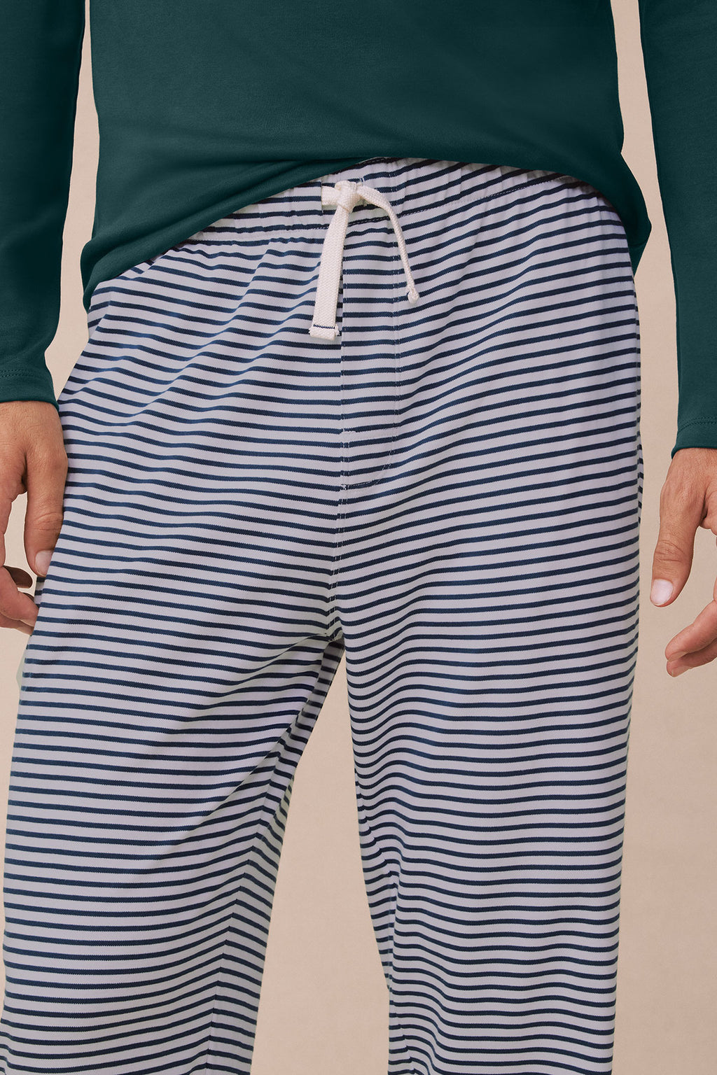 Dark teal long-sleeve top with navy and white striped long pants, drawstring waist.