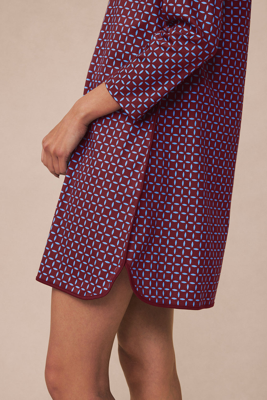 Burgundy nightgown with blue starburst pattern, long sleeves, worn by model showing side view and hem detail.