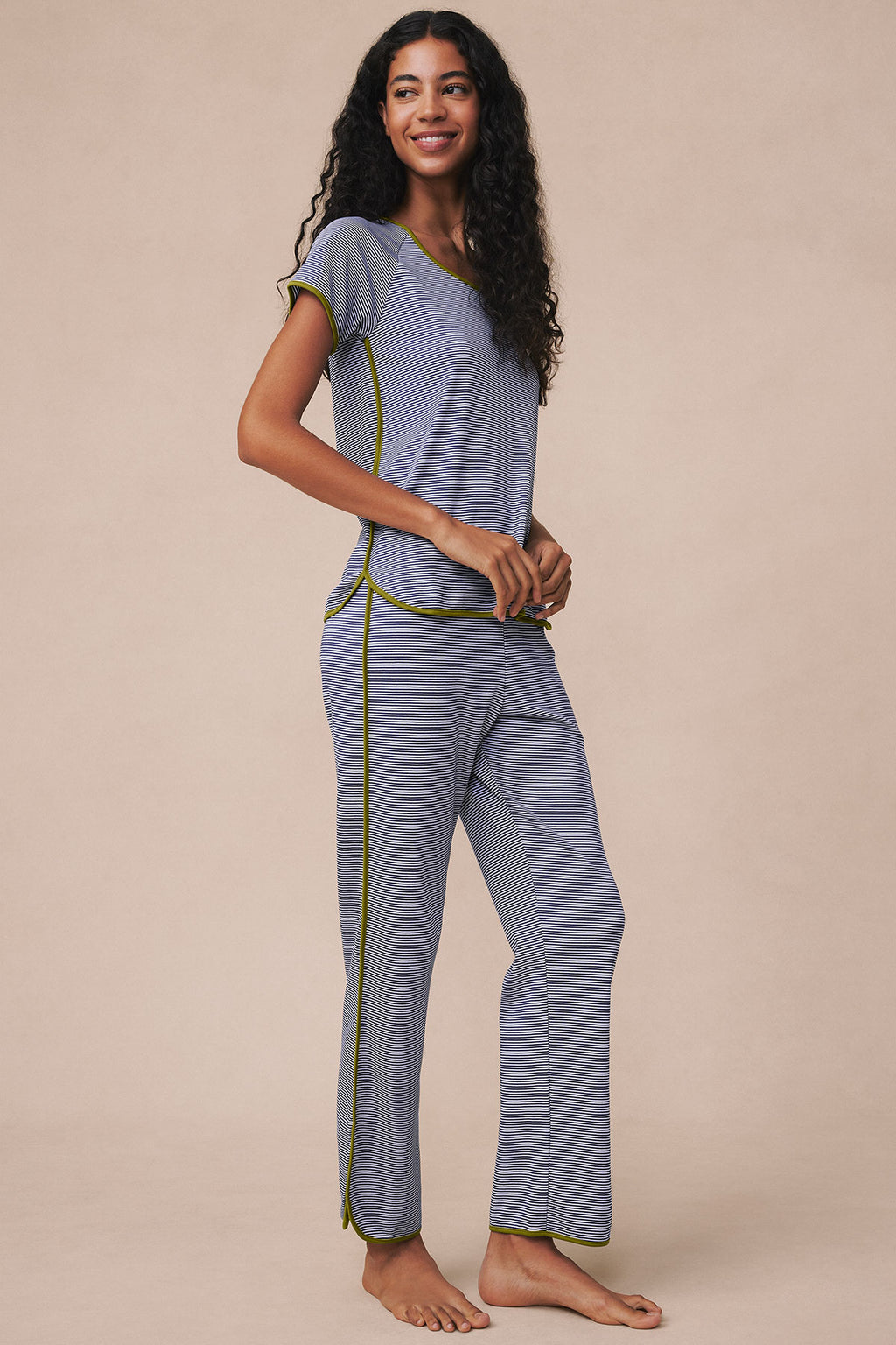 Woman wearing navy and white striped short-sleeve top and matching full-length pants with yellow trim.