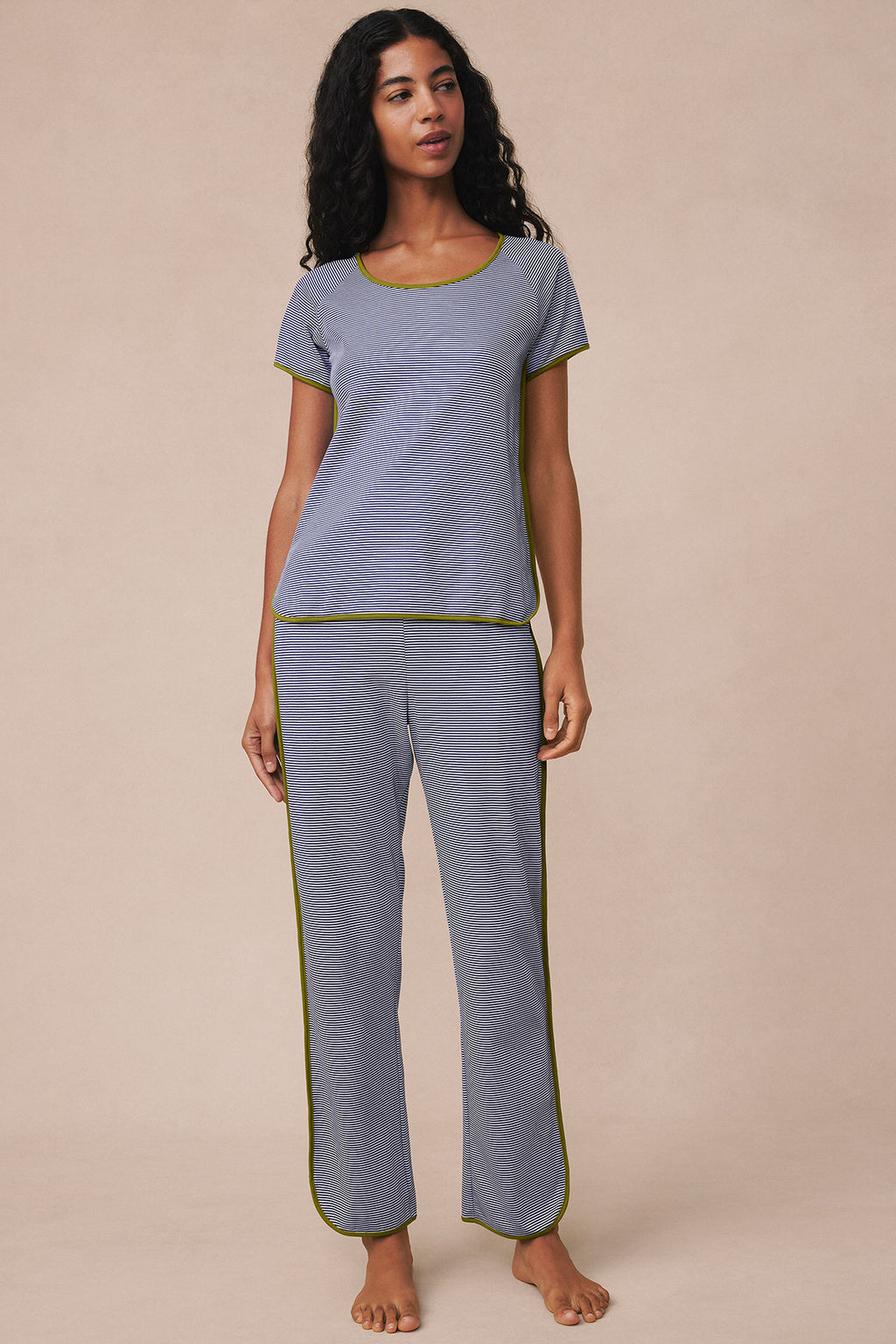 Woman wearing navy mini striped short-sleeve shirt and matching long pants with yellow trim.