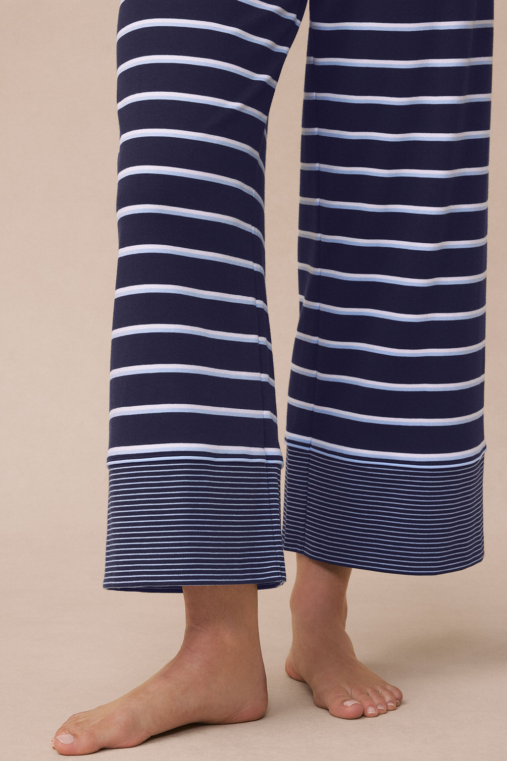 Navy and white striped pajama pants with wide legs and ribbed cuffs shown on model.