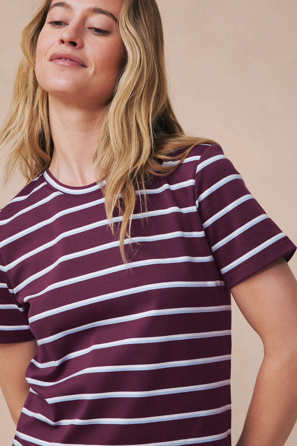Woman wearing burgundy and white striped crew neck short-sleeve shirt.