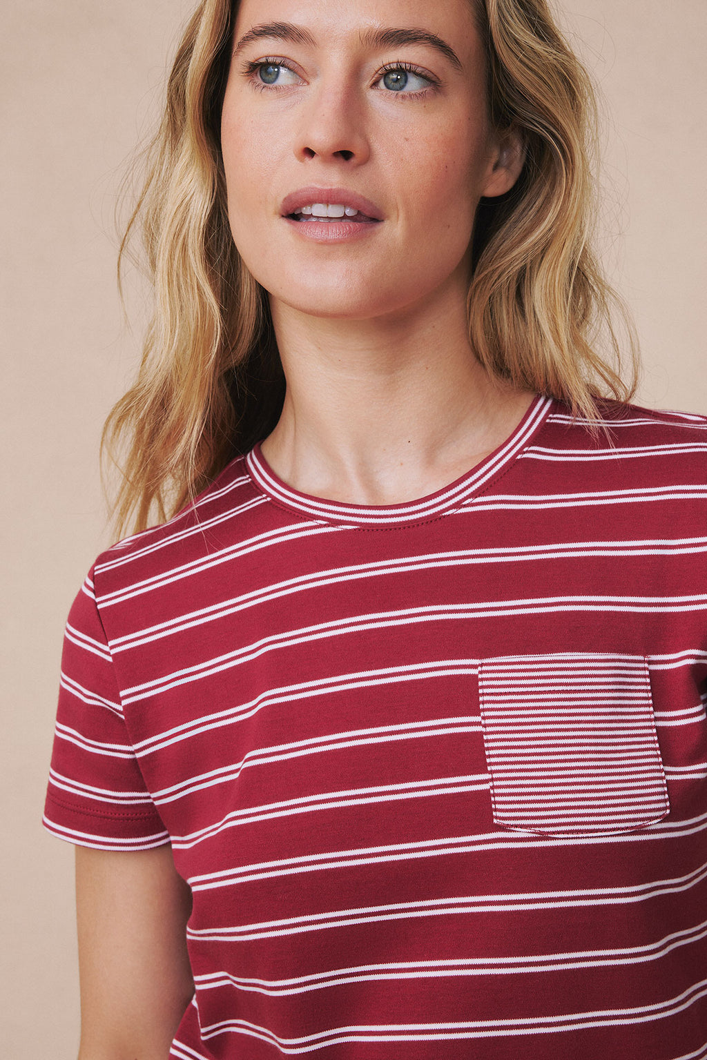 Woman wearing garnet and white striped crew neck pajama top with short sleeves and chest pocket.