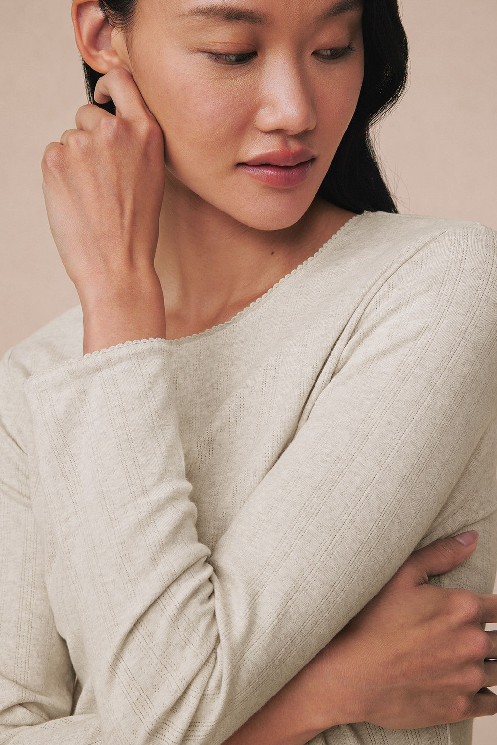 Oat heather pointelle long-sleeve top with textured knit fabric and crew neckline on model.