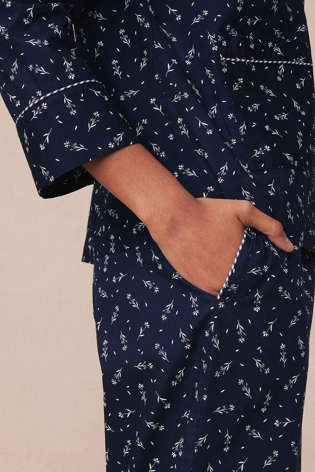 Navy pajama set with white floral botanical print and piped trim detail at pocket and cuffs.