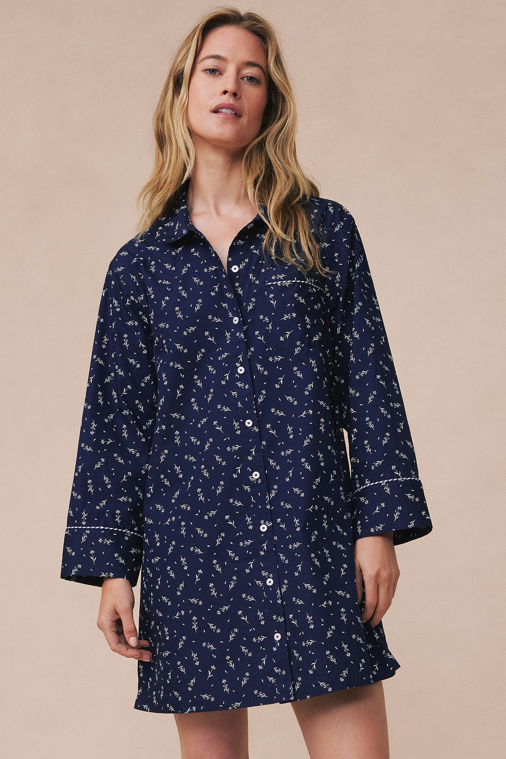Navy nightgown with small floral print, button front, piped trim, and three-quarter length sleeves.