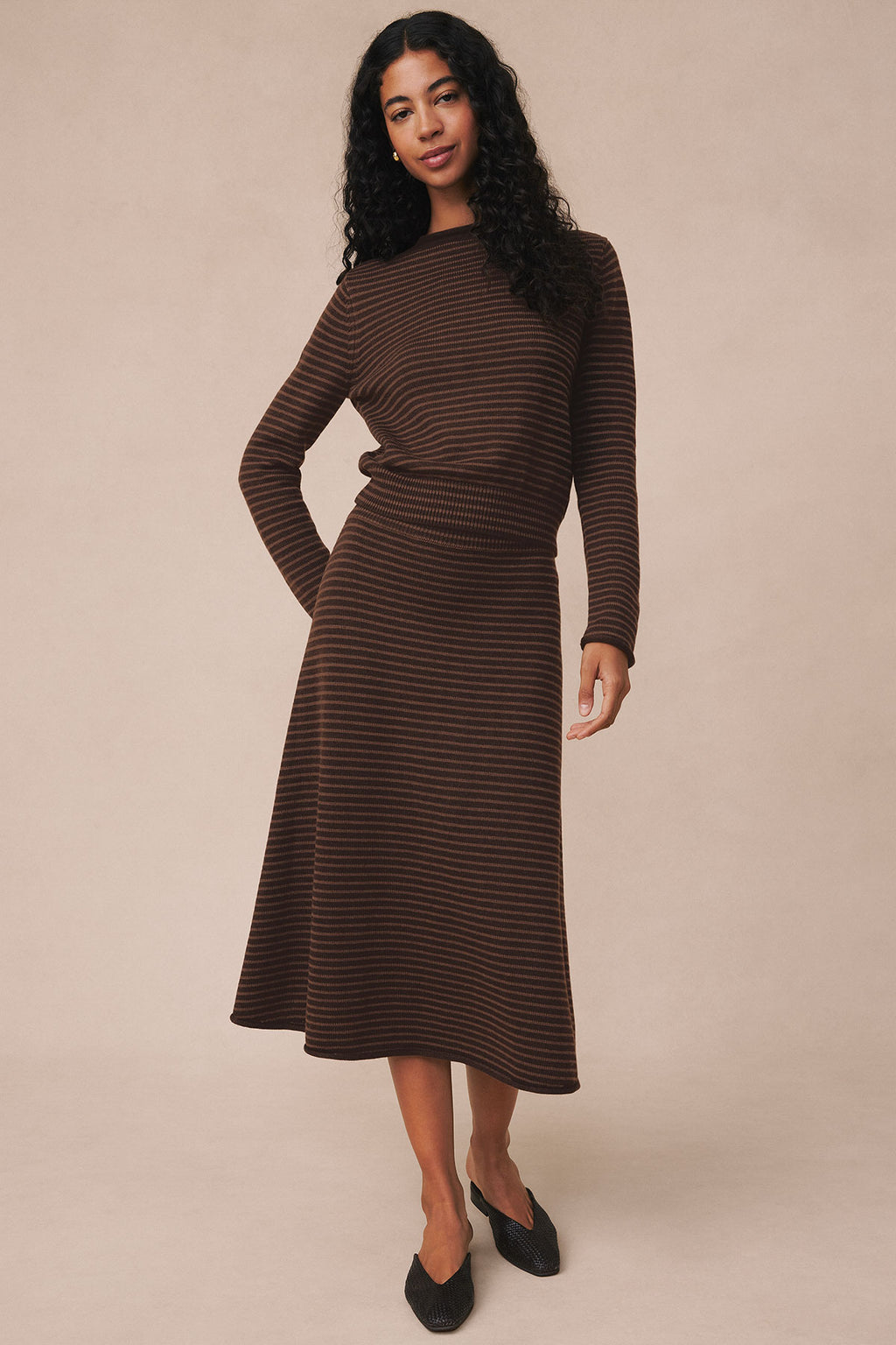 Brown striped long-sleeve sweater and midi skirt set worn with black slip-on shoes.