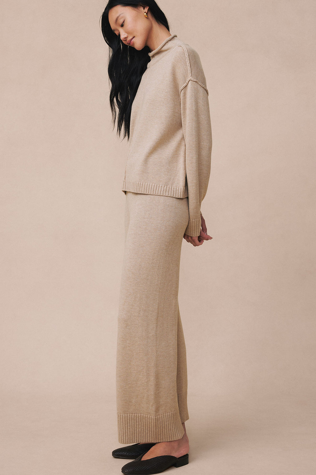 Woman wearing a beige knit sweater and matching maxi skirt set with ribbed trim details.