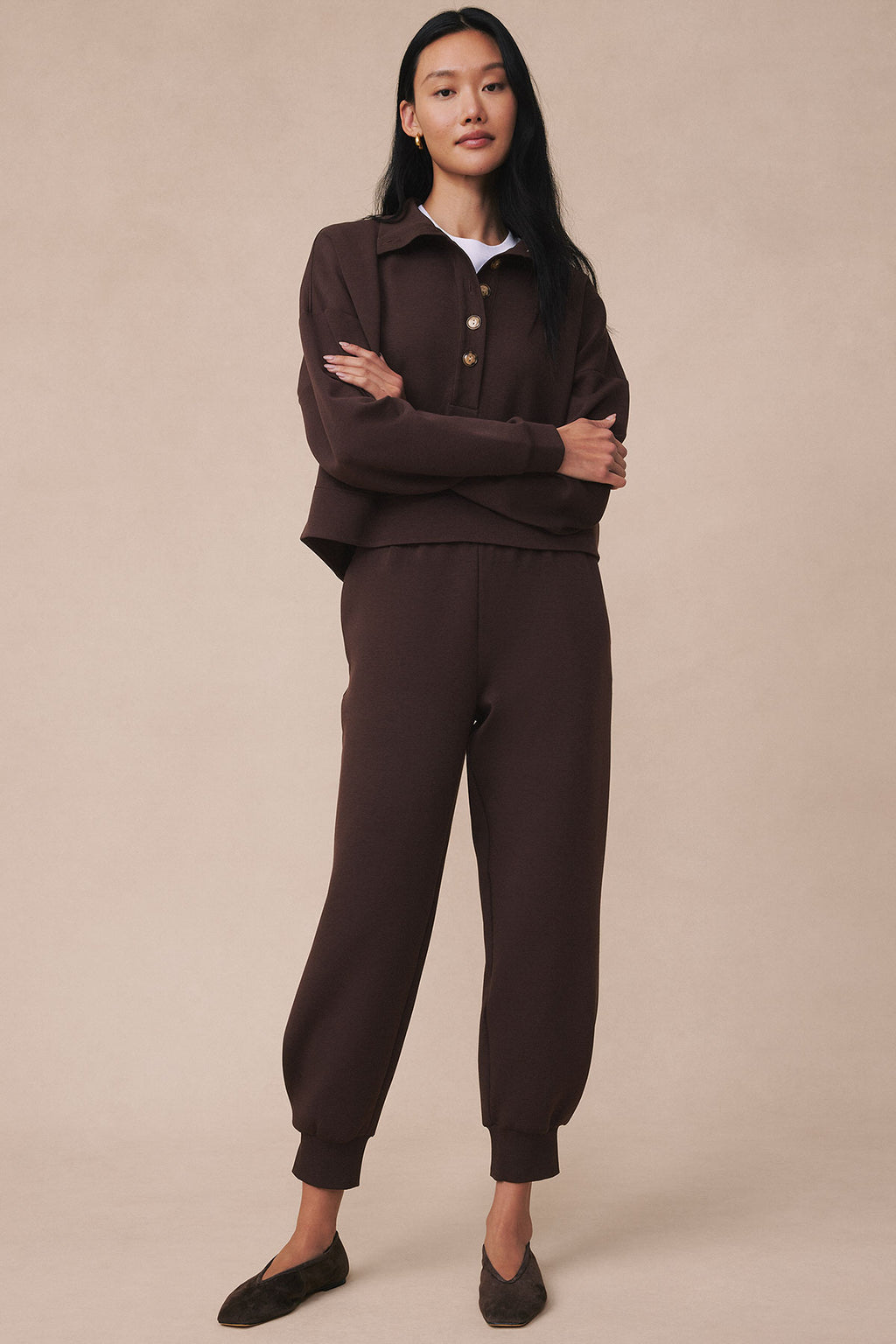 Woman wearing espresso brown pullover top with button front and matching jogger pants with elastic cuffs.