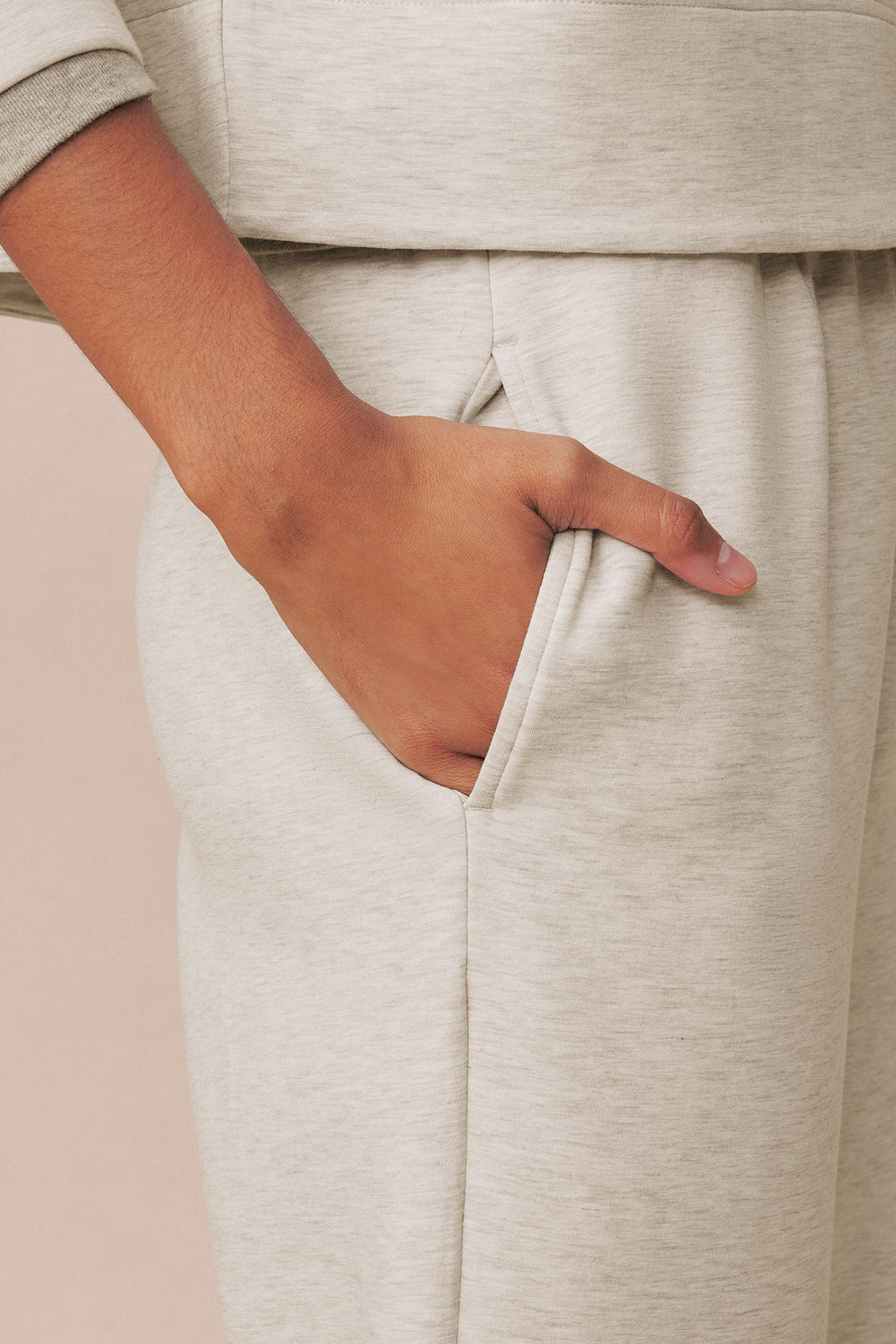 Oat heather pullover and jogger pants set with ribbed cuffs and front pocket detail on model.