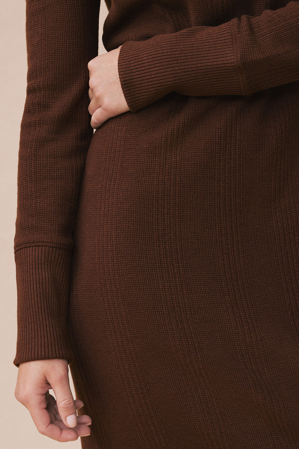 Brown waffle knit long sleeve midi dress with ribbed cuffs and hem, shown on model from torso down.