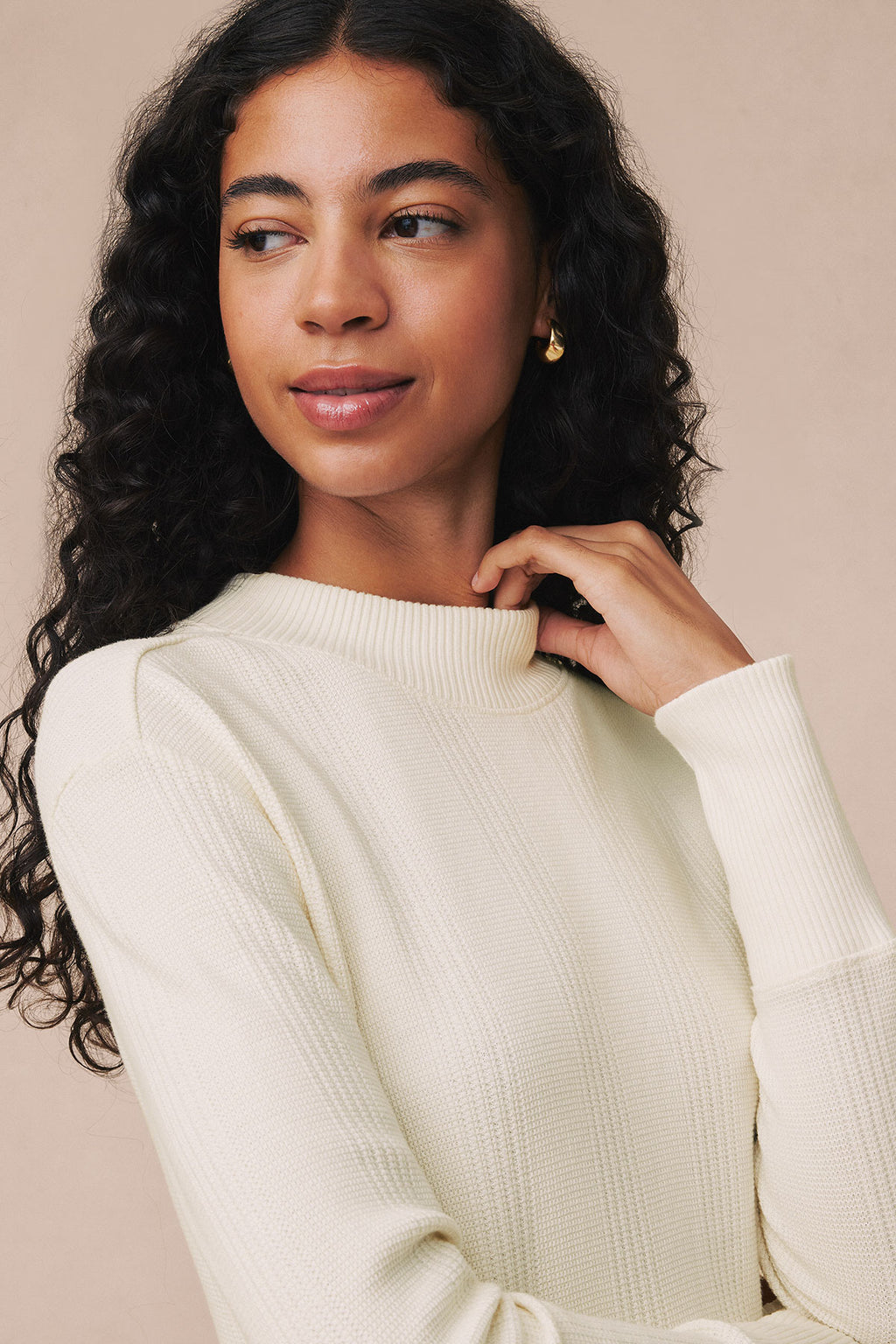 Ivory waffle-knit long sleeve dress with crew neckline worn by model against neutral background.
