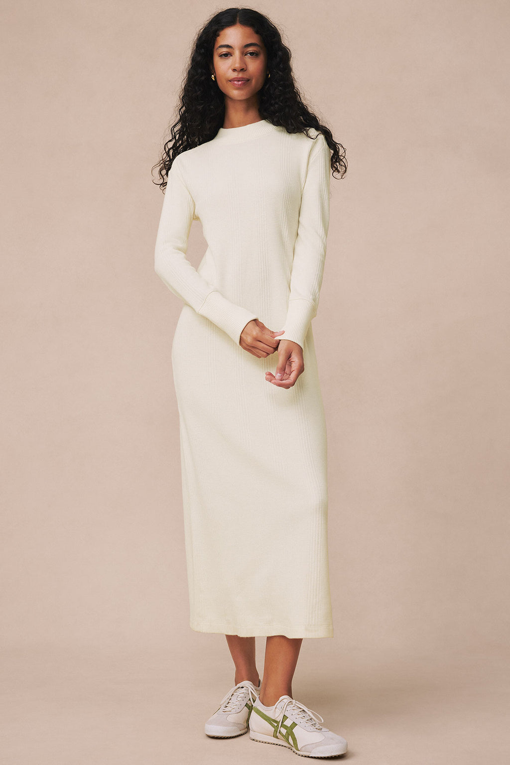 Ivory ribbed long-sleeve midi dress with crew neckline, worn with white sneakers.
