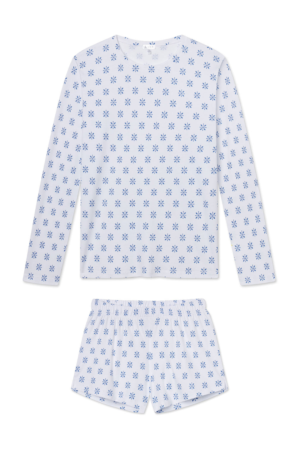 The Pima Crew Long-Short Set in Seaport Moroccan Blockprint features a soft Pima cotton long-sleeve crew-neck top and shorts in light blue, decorated with blue floral shapes inspired by Moroccan blockprint designs.