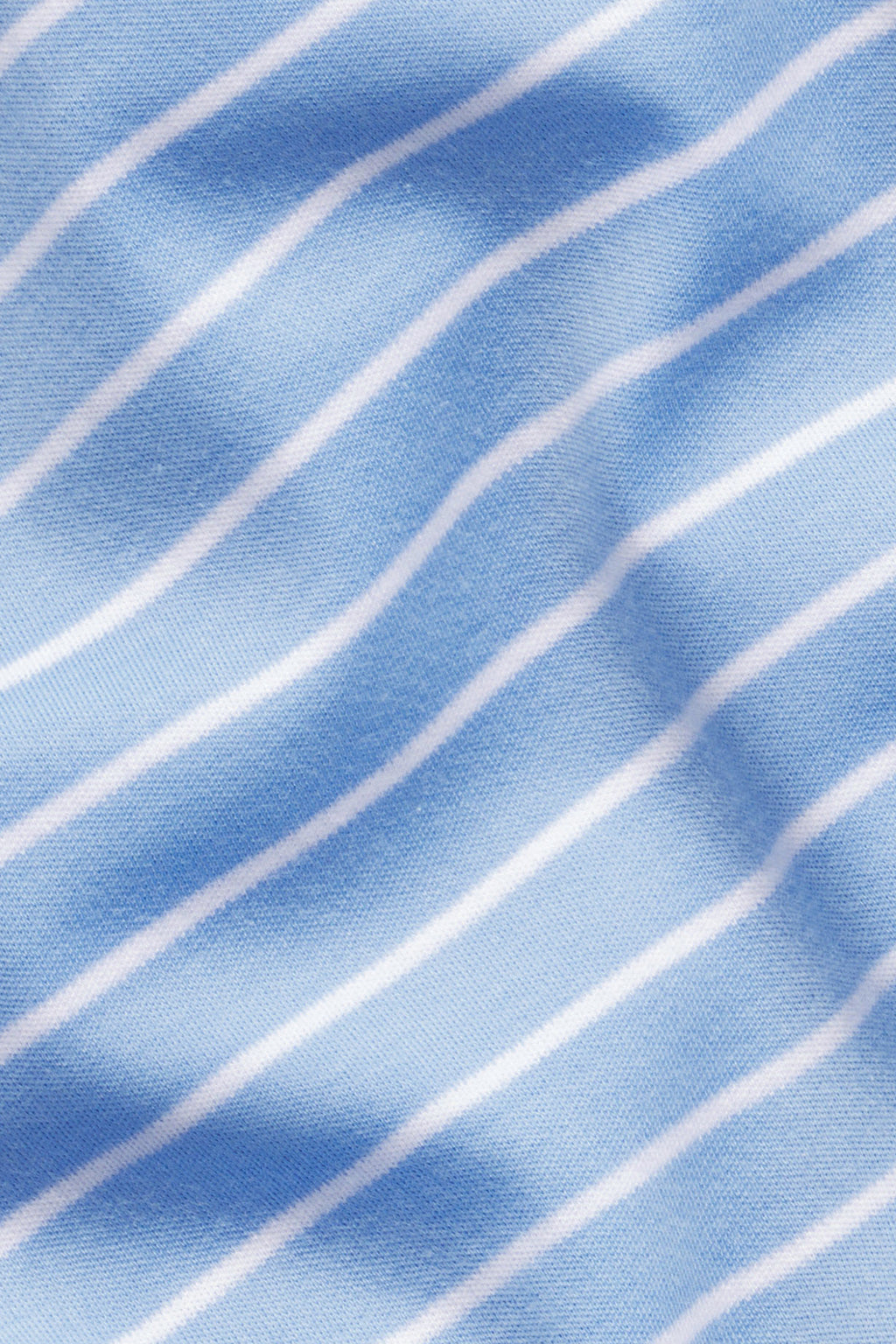 Light blue fabric with thin white stripes and soft folds, ideal for our Pima Crew Wide Leg Pajama Set in Mixed Baltic Blue Stripe made from 100% Pima Cotton.