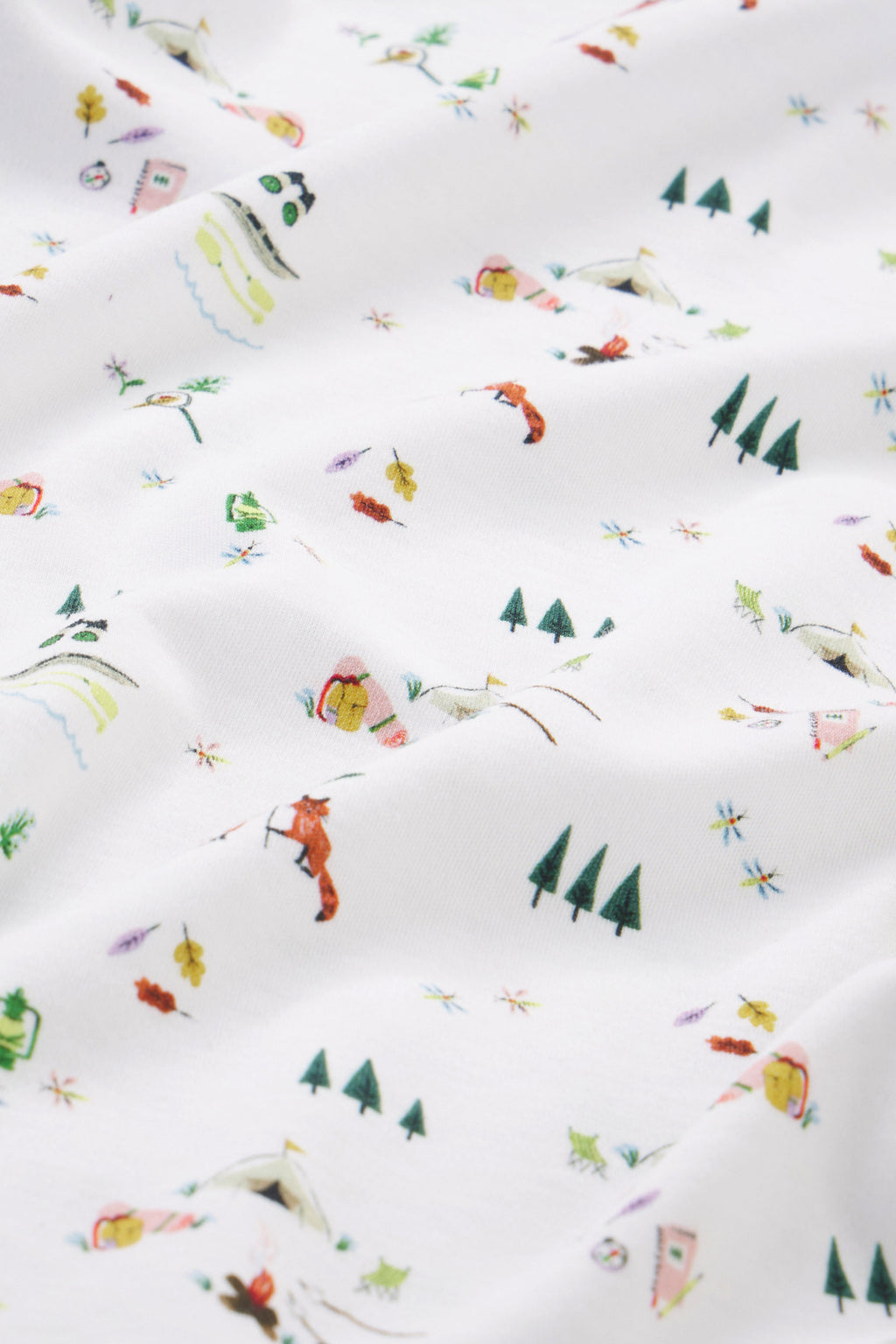 Kids Shorts Set in Camp LAKE features white Pima cotton fabric with a whimsical camp-themed print of foxes, trees, tents, campfires, and leaves—perfect for playful summer adventures.