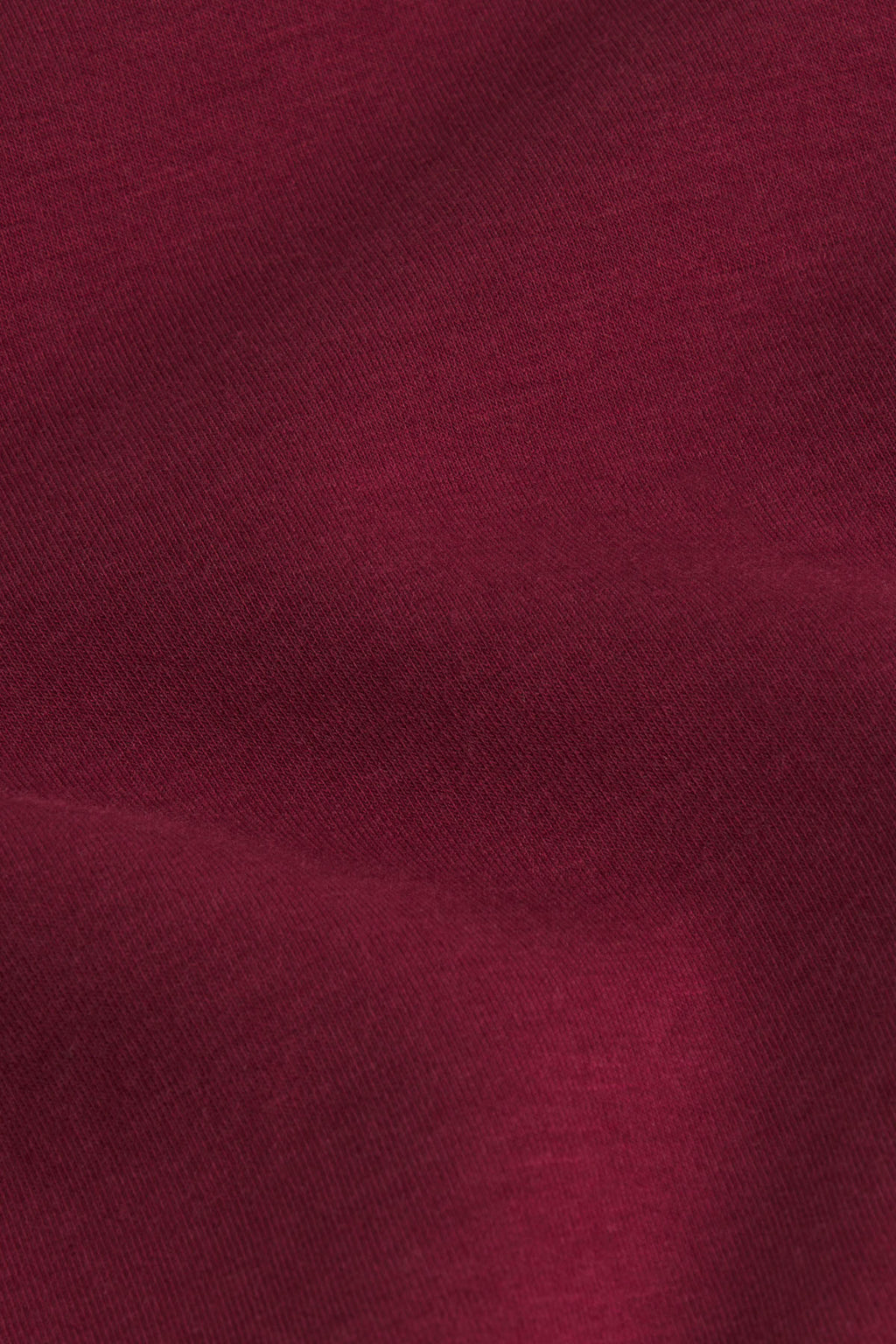 Burgundy ribbed fabric texture with diagonal weave pattern.