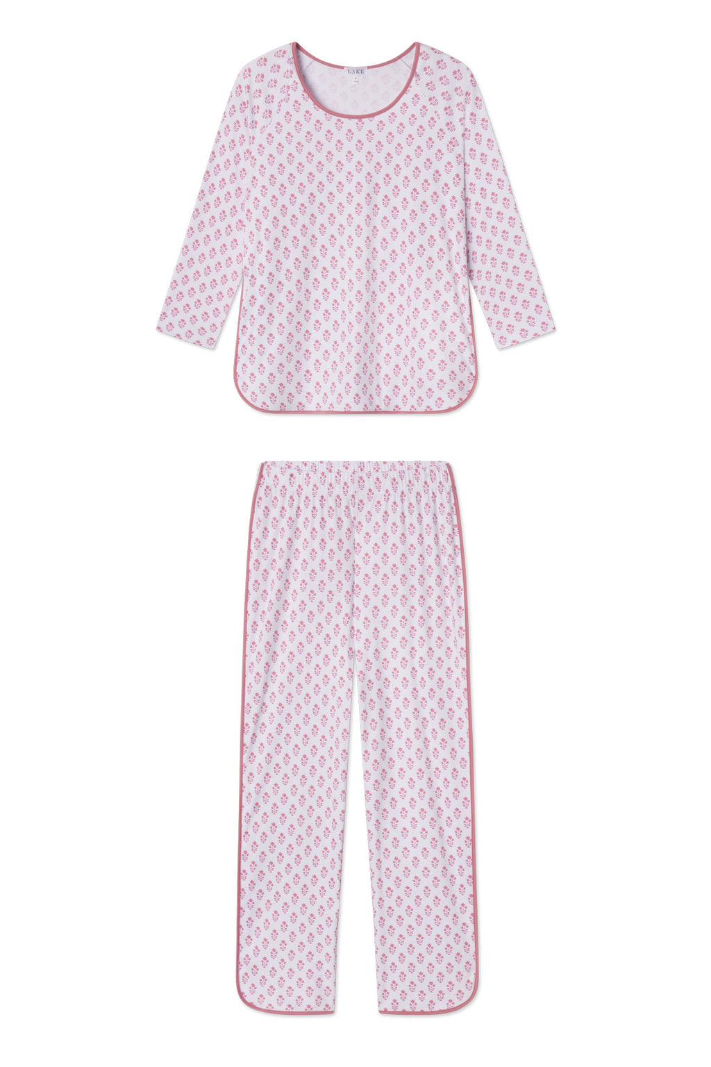 The Pima Long-Long Set in Light Camellia Posy is a women’s two-piece pajama set made of soft Pima cotton. It features a white background with pink floral print, a long-sleeve top, and full-length pants with an elastic waistband and pink trim.