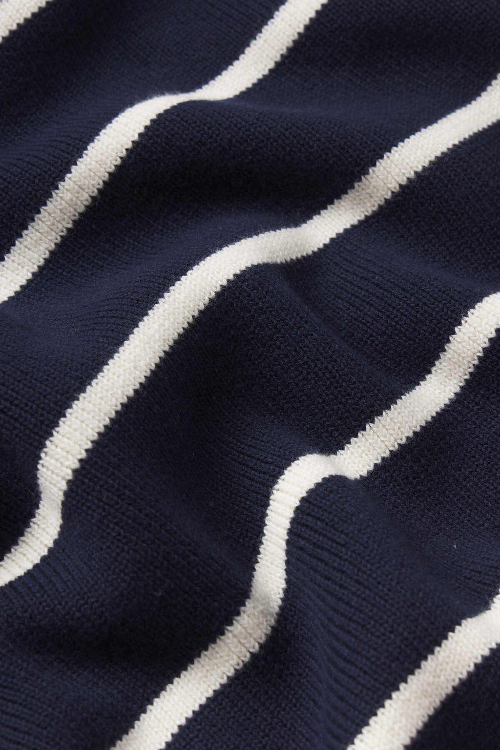 Close-up of the Madeline Sweater in English Navy Banker Stripe, featuring a textured knit fabric with evenly spaced, horizontal white stripes for a cozy look.