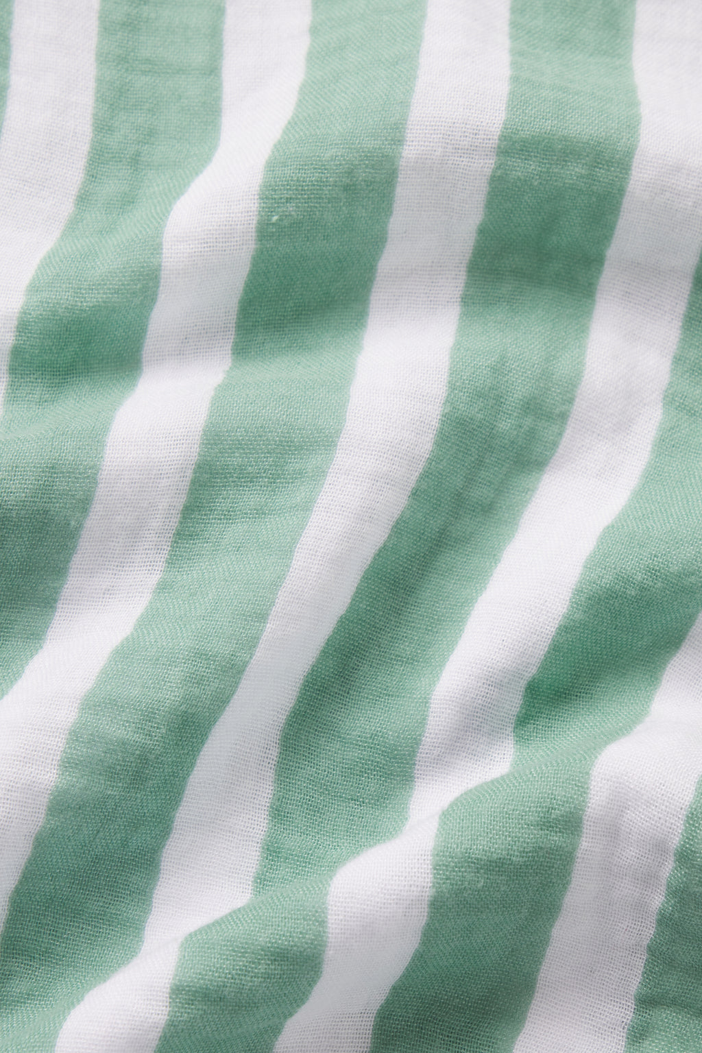 Close-up of the Nantucket Shorts Set in Granite Green Sail Stripe, featuring cotton gauze fabric with alternating green and white stripes. The slightly wrinkled surface adds to its textured appearance.